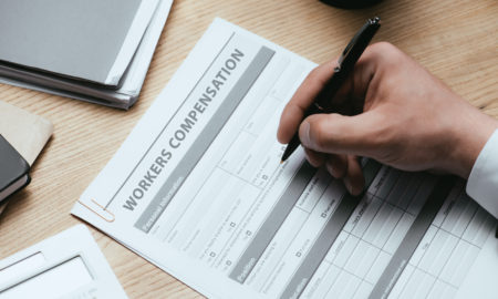 Cropped image of a man filling out a workers’ compensation claim form